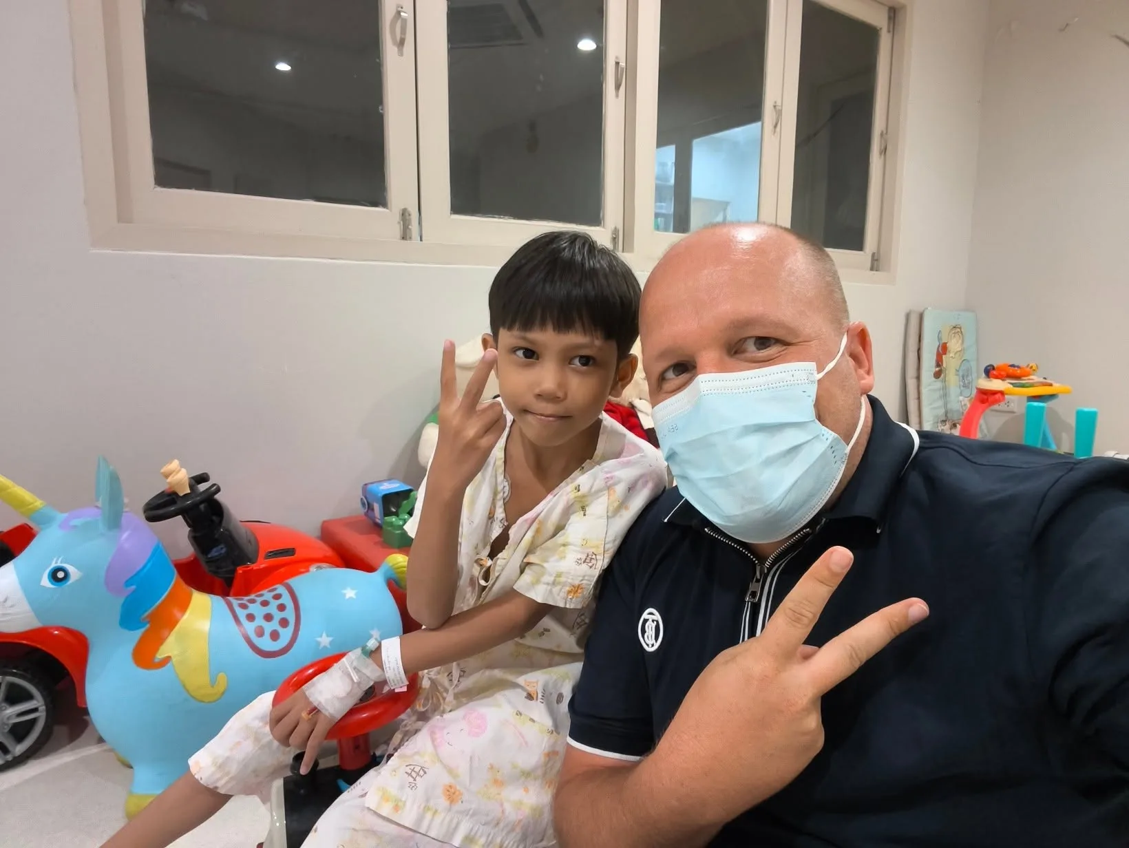 Lin Lin Htet dans la salle de jeux du service, faisant le signe de la victoire à côté d'un membre de l'équipe