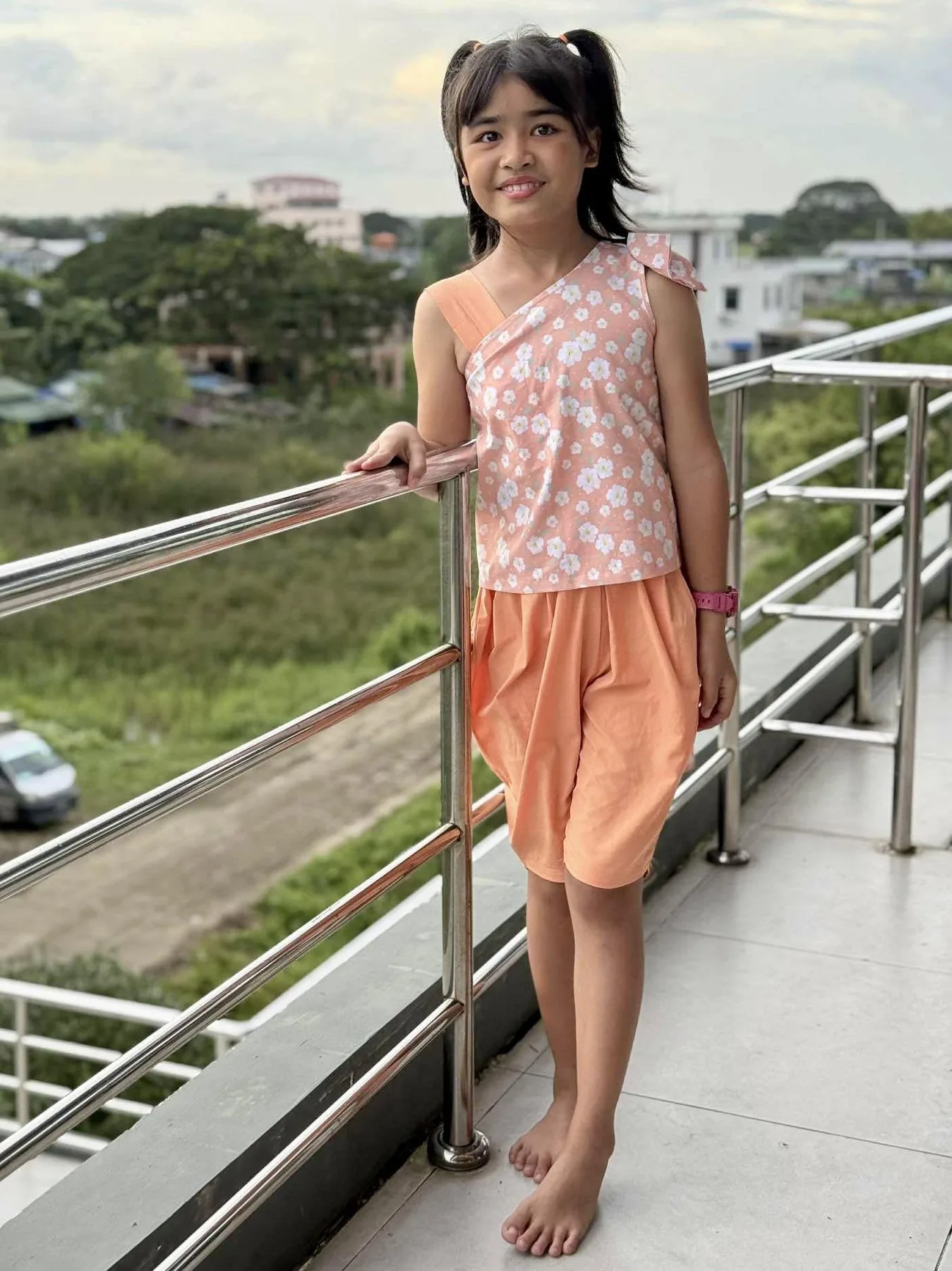 Ngaih No aujourd'hui, debout sur une terrasse à Rangoun, souriante