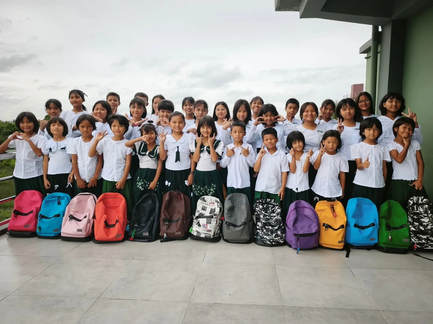 All the boarding-house residents together in uniform on the terrace, their bags lined up in front of them
